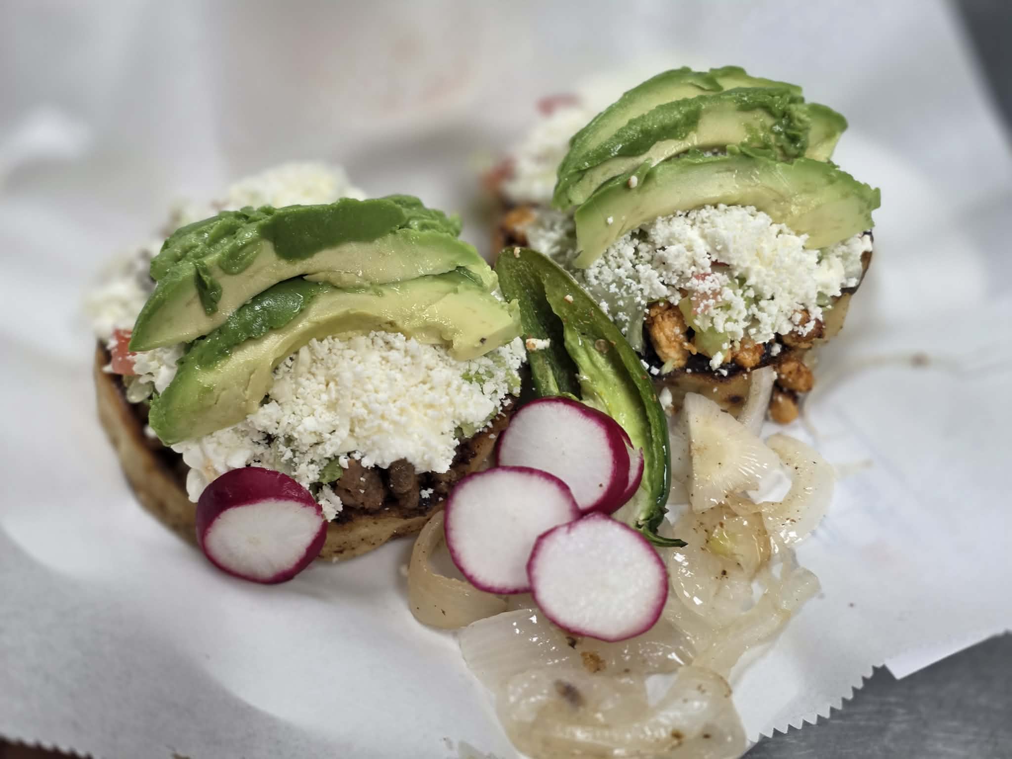 Mexican sopes topped with avocado and cheese